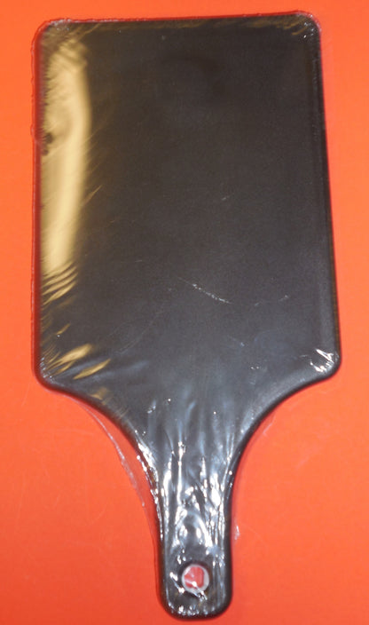 Black Cutting Board Paddle on Orange Table. Side B