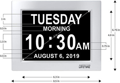 Silver and black clock displaying the date, time and day